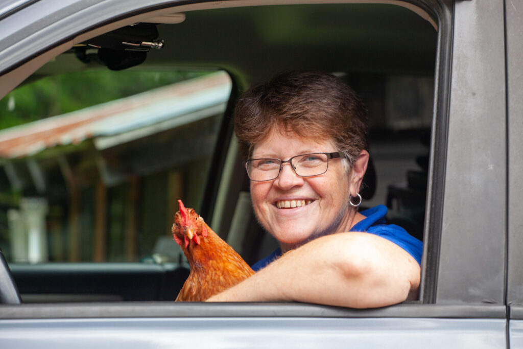 A handywoman in a truck with her chicken