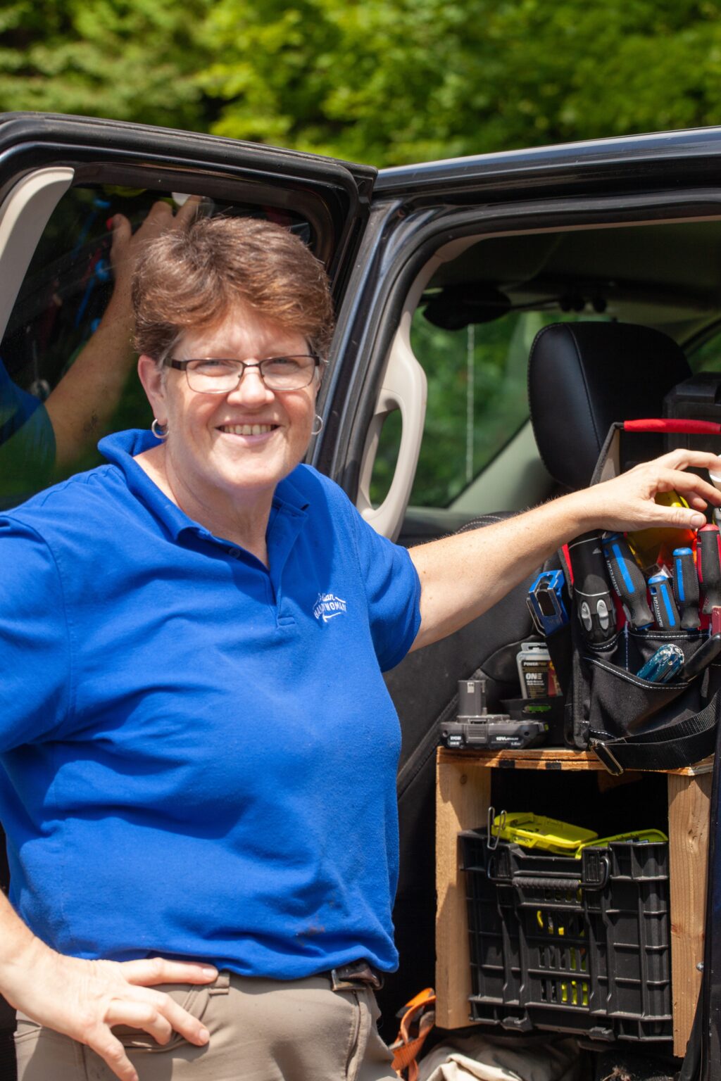A handywoman standing ready beside her truck
